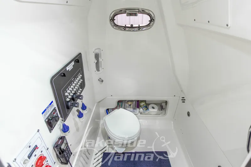 Slide: The Image of 2023 Boston Whaler 250 Outrage interior with marine toilet and control panel. - 47