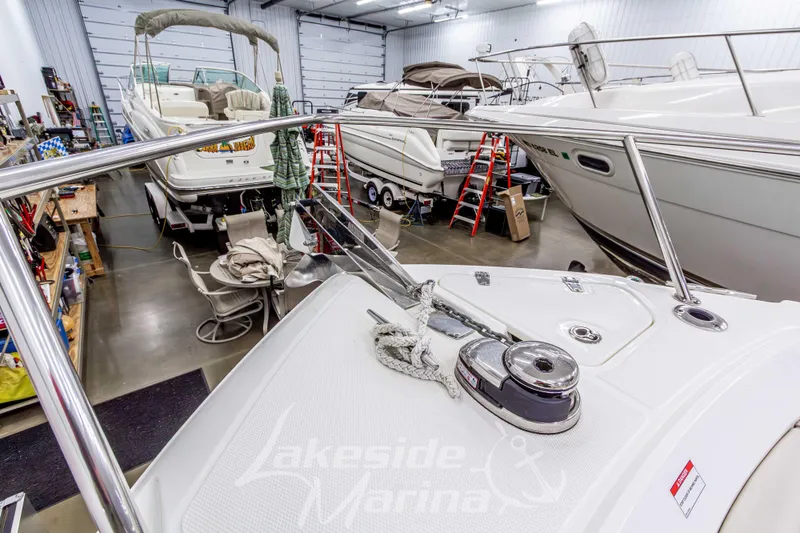 Slide: The Image of 2023 Boston Whaler 250 Outrage in marina workshop, surrounded by other boats and equipment. - 58