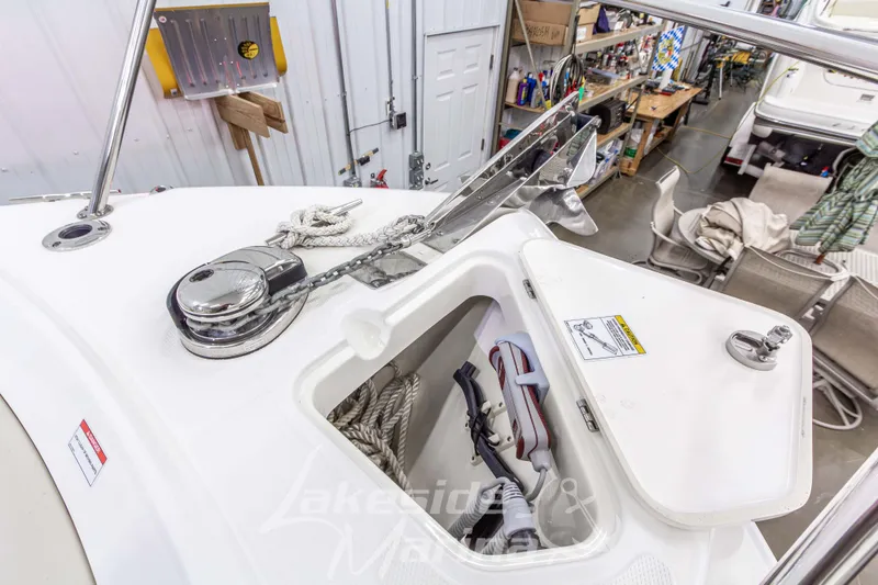 Slide: The Image of 2023 Boston Whaler 250 Outrage anchor locker with rope and winch in a workshop setting. - 59