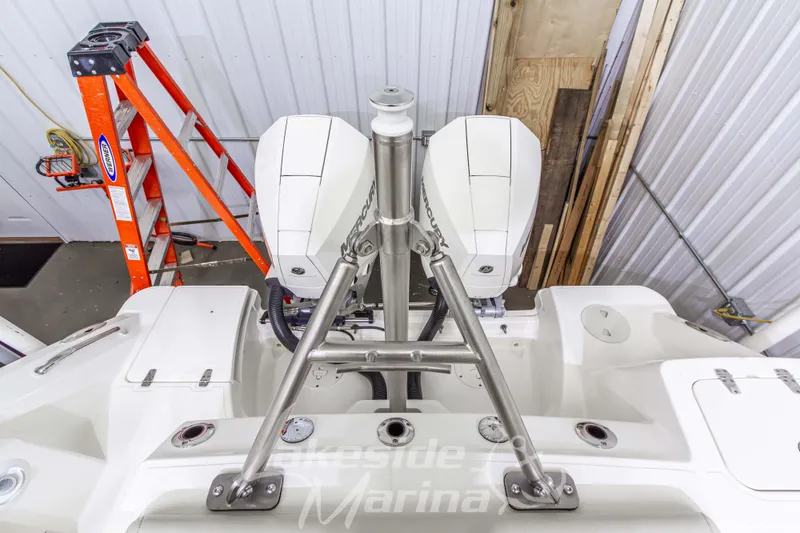 Slide: The Image of 2023 Boston Whaler 250 Outrage with dual Mercury outboard engines in a garage setting. - 8