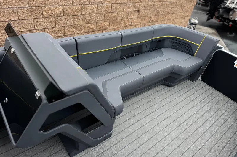 Slide: The Image of 2025 Manitou EXPLORE 24 boat interior with sleek gray seating and yellow accents. - 11