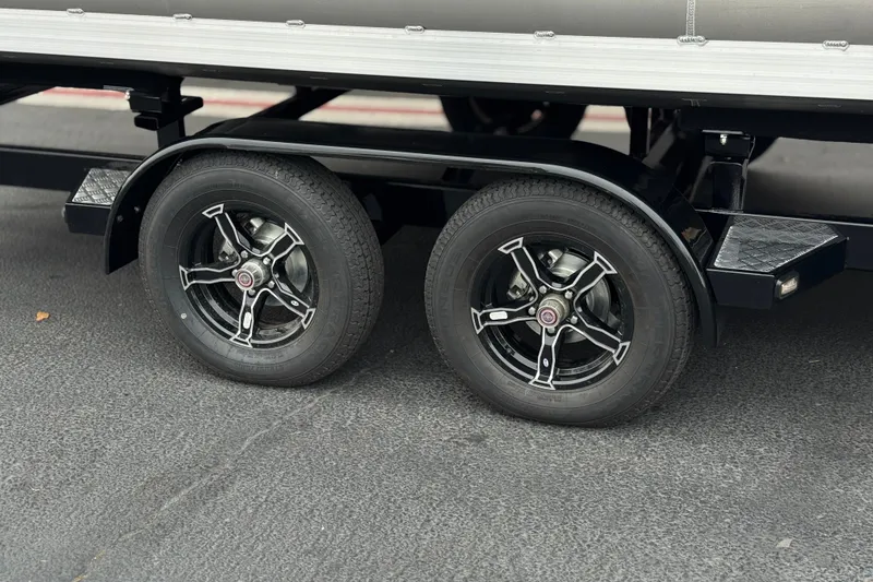 Slide: The Image of Trailer wheels of a 2025 Manitou EXPLORE 24 on asphalt pavement. - 27