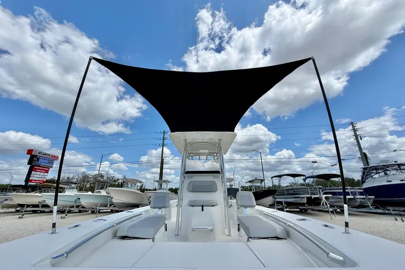 Slide: The Image of Bay Rider 2260 FS Skiff 2027 with canopy, displayed under a bright blue sky. - 10
