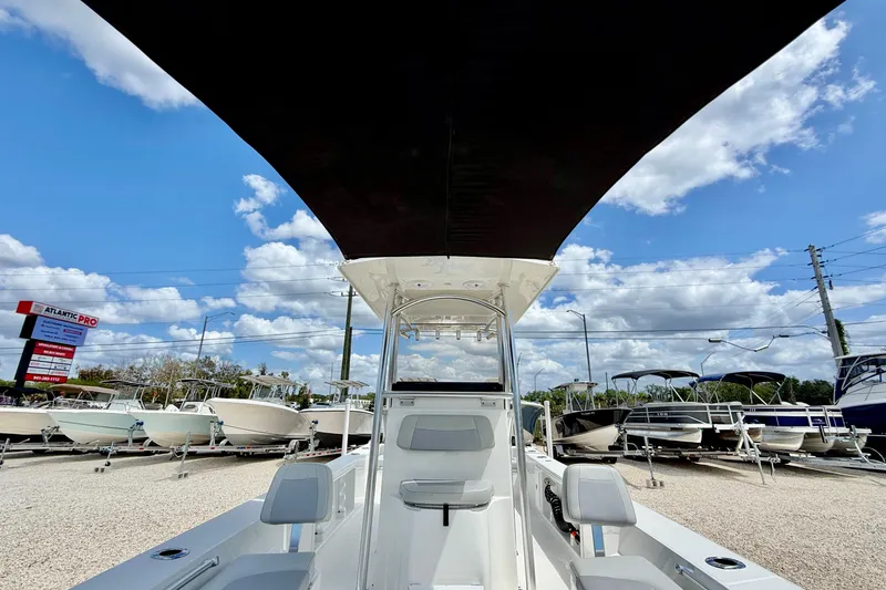 Slide: The Image of Bay Rider 2260 FS Skiff 2027 model displayed at a boat dealership under a sunny sky. - 14