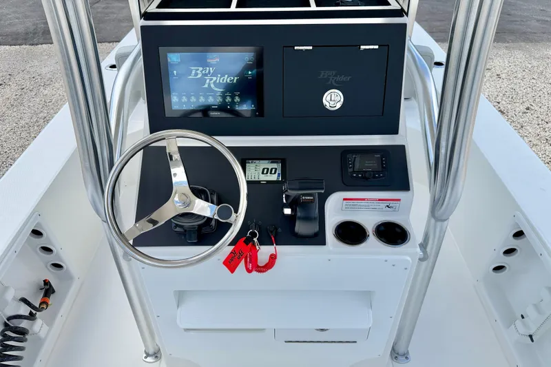 Slide: The Image of 2027 Bay Rider 2260 FS Skiff console with steering wheel and electronic controls. - 22