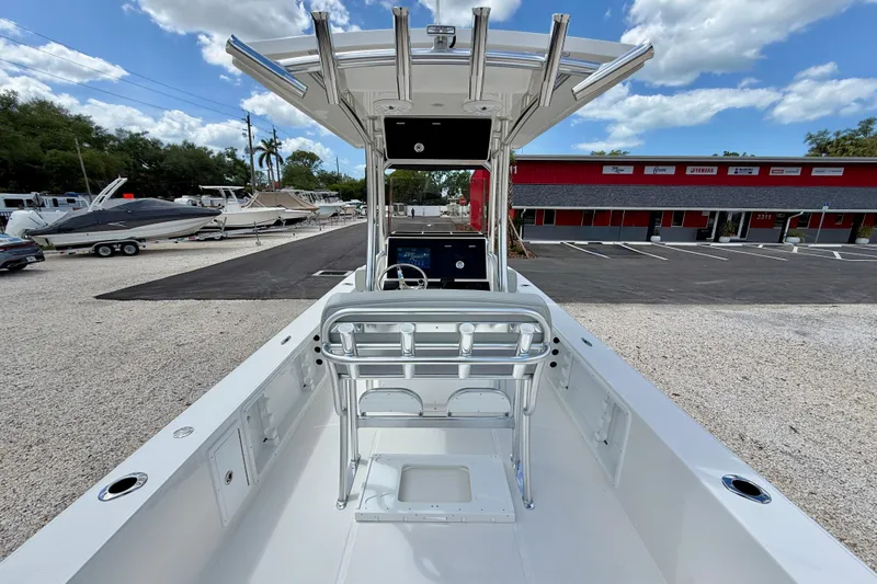 Slide: The Image of 2027 Bay Rider 2260 FS Skiff boat with T-top, parked outdoors under blue sky. - 30