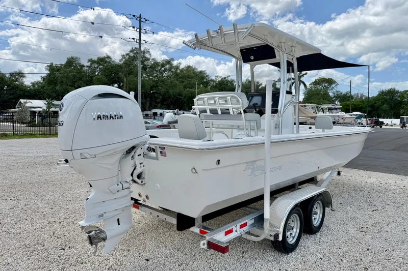 Slide: The Image of Bay Rider 2260 FS Skiff 2027 on trailer with Yamaha outboard motor, parked outdoors. - 5