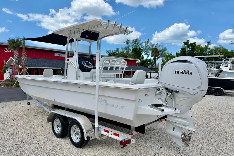 Slide: The Image of Bay Rider 2260 FS Skiff 2027 model with Yamaha outboard, parked on gravel lot. - 7