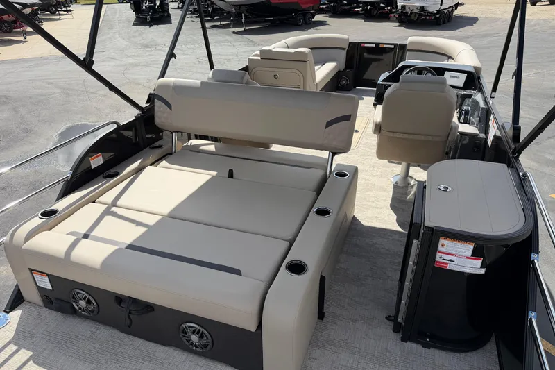 Slide: The Image of 2026 Crest Conquest 230 SLSC pontoon boat interior with beige seating and modern amenities. - 12