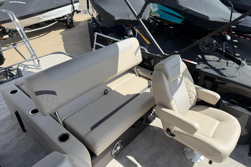 Slide: The Image of 2026 Crest Conquest 230 SLSC boat interior with beige seating and cup holders. - 16