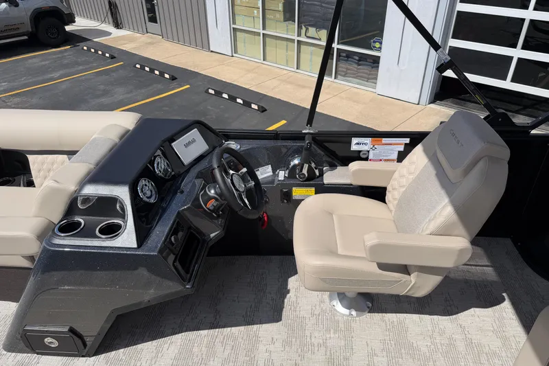 Slide: The Image of Helm of 2026 Crest Conquest 230 SLSC boat with beige captain's chair and dashboard controls. - 17