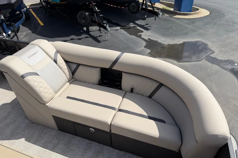 Slide: The Image of 2026 Crest Conquest 230 SLSC boat seating, beige upholstery, cup holders, outdoor setting. - 20