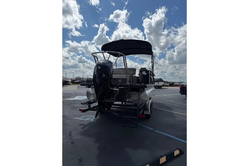 Slide: The Image of 2026 Crest Conquest 230 SLSC boat with canopy, parked under a cloudy sky. - 5