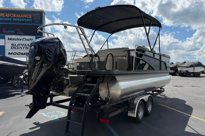 Slide: The Image of 2026 Crest Conquest 230 SLSC pontoon boat on trailer at marina under blue sky. - 6