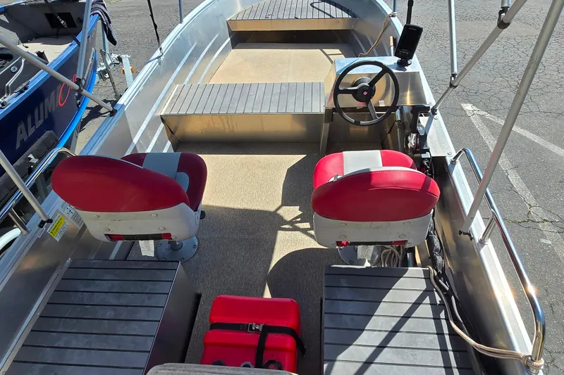 Slide: The Image of 2023 Marlon MV 16 boat interior with red seats, steering wheel, and storage compartments. - 4