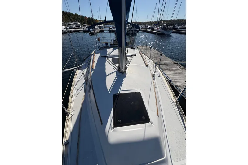 Slide: The Image of 1993 Hunter 28 sailboat docked at marina, showcasing deck and rigging. - 11