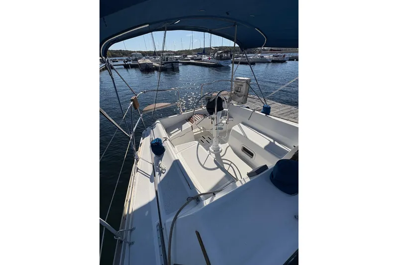 Slide: The Image of 1993 Hunter 28 sailboat cockpit view at marina, showcasing seating and steering wheel. - 16