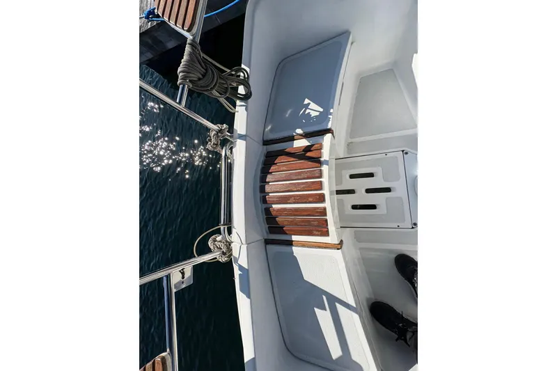 Slide: The Image of Cockpit view of a 1993 Hunter 28 sailboat with wooden accents and sparkling water. - 18