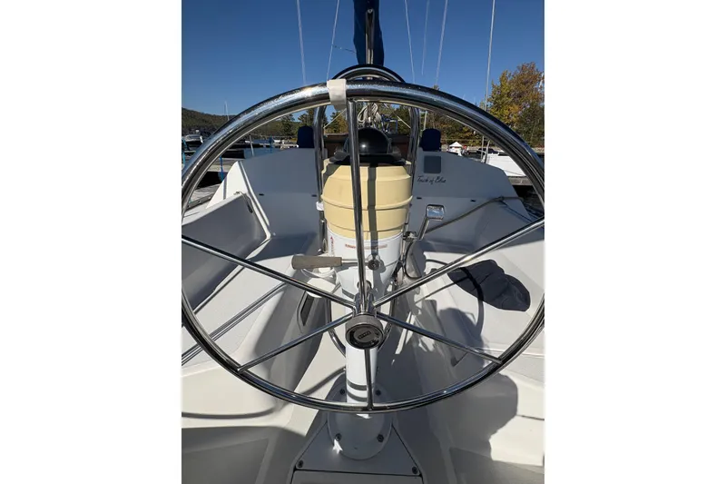 Slide: The Image of Steering wheel of a 1993 Hunter 28 sailboat under clear blue skies. - 20