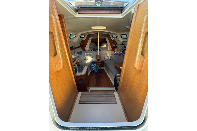 Slide: The Image of Interior view of a 1993 Hunter 28 sailboat cabin with wooden finishes. - 27