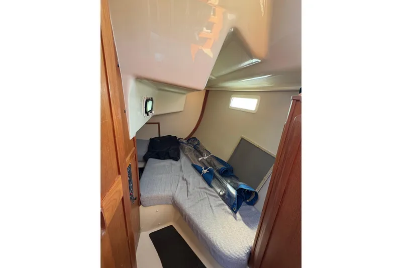Slide: The Image of Cozy cabin interior of a 1993 Hunter 28 sailboat with bedding and storage. - 29