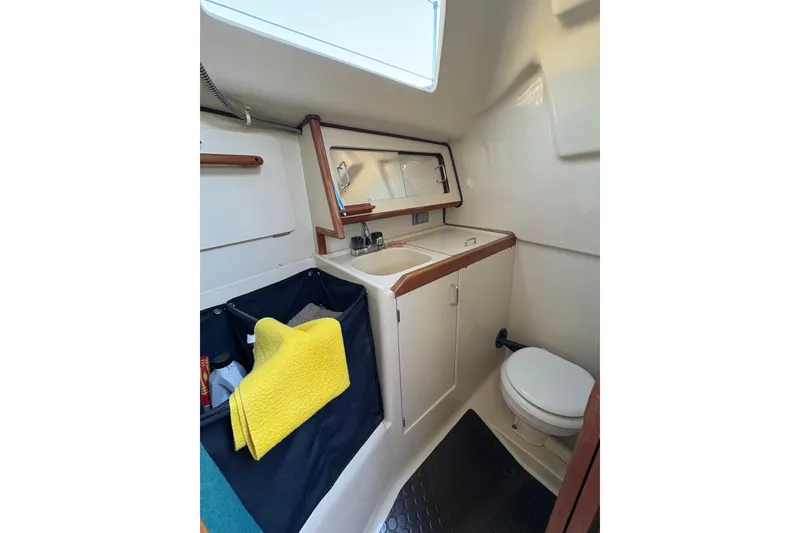 Slide: The Image of Compact bathroom in a 1993 Hunter 28 sailboat with sink, storage, and toilet. - 33