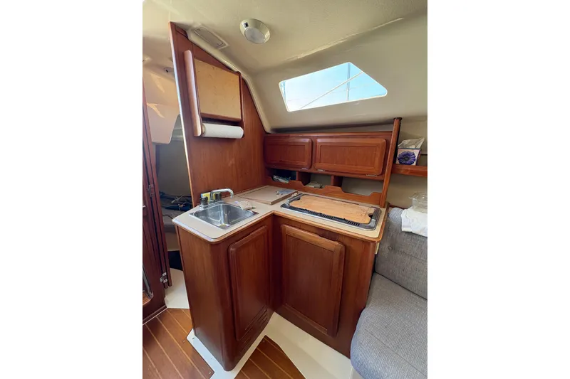 Slide: The Image of Interior of 1993 Hunter 28 sailboat galley with wooden cabinetry and compact sink. - 48