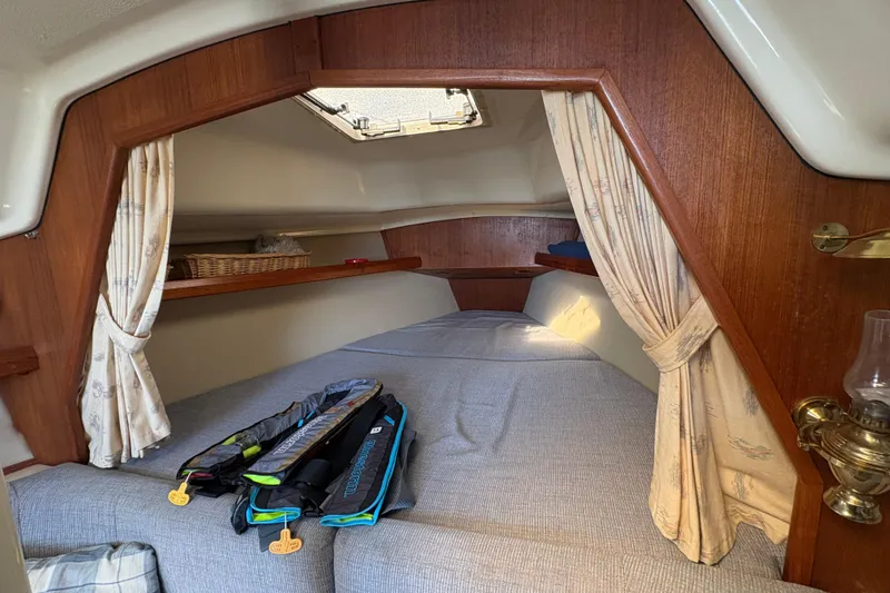 Slide: The Image of Cozy cabin interior of a 1993 Hunter 28 sailboat with wood accents and soft bedding. - 50