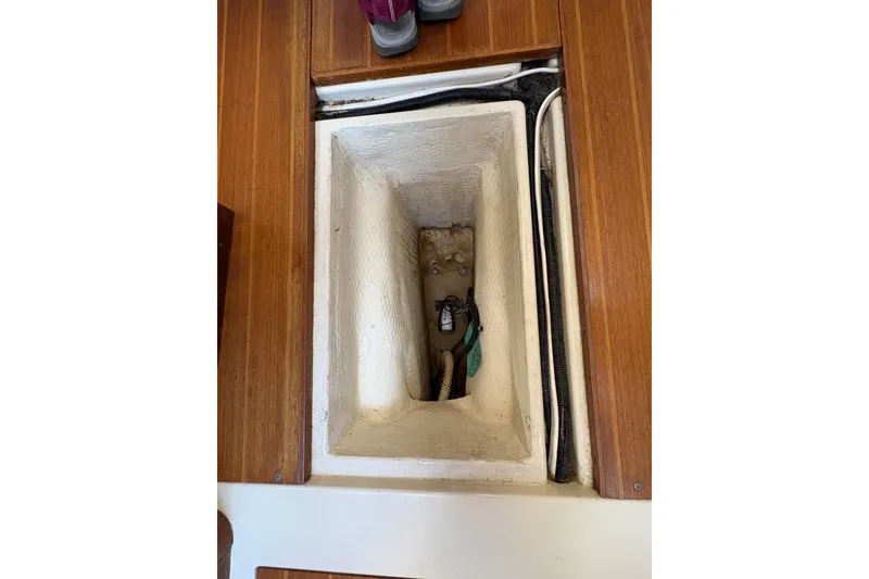 Slide: The Image of Bilge compartment of a 1993 Hunter 28 sailboat with visible wiring and hoses. - 56