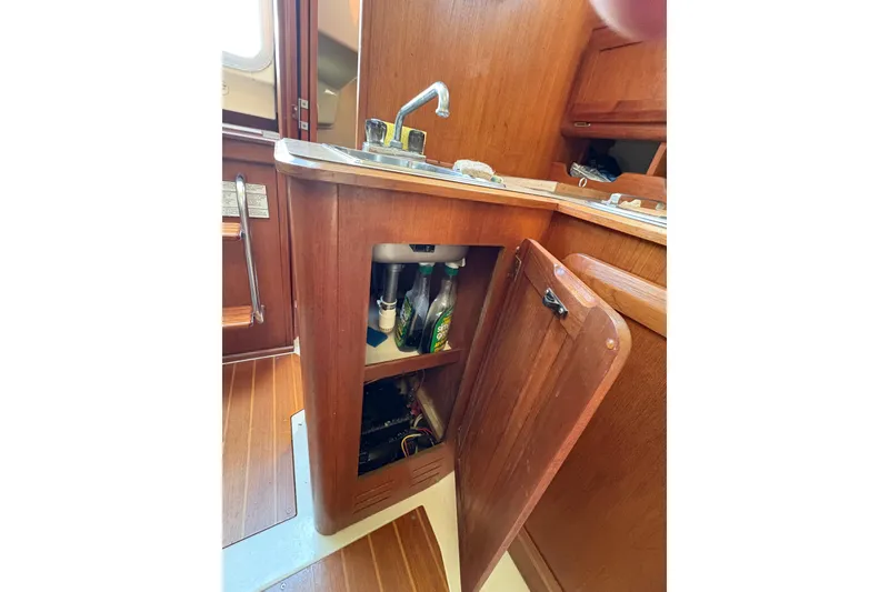 Slide: The Image of Interior of 1993 Hunter 28 sailboat showing wooden cabinetry and sink area. - 58