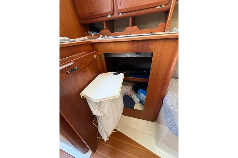 Slide: The Image of Interior of a 1993 Hunter 28 sailboat showing wooden cabinetry and storage space. - 59
