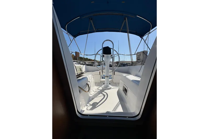 Slide: The Image of Cockpit view of a 1993 Hunter 28 sailboat with blue canopy and steering wheel. - 61
