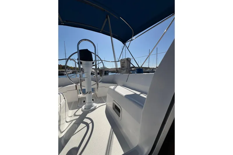 Slide: The Image of Cockpit view of a 1993 Hunter 28 sailboat with blue canopy and steering wheel. - 62