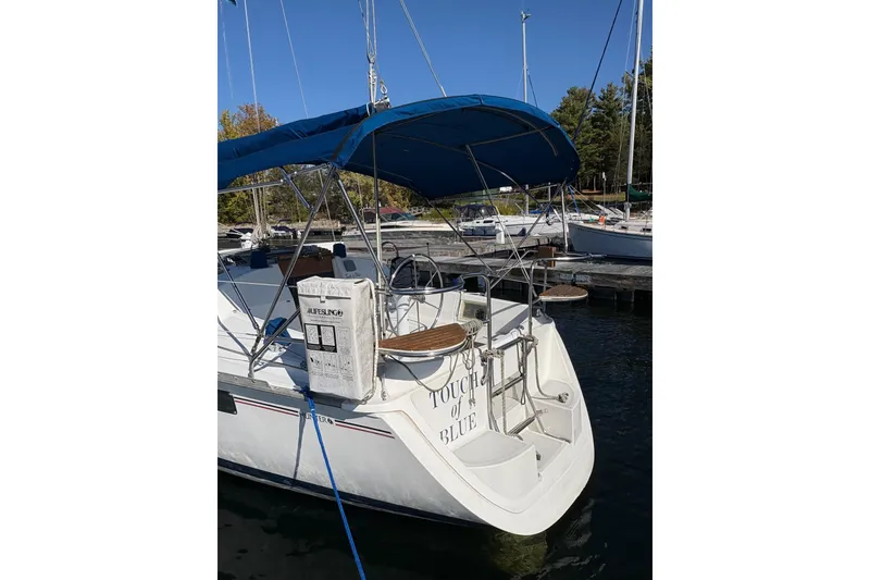 Slide: The Image of 1993 Hunter 28 sailboat docked with blue canopy and lifebuoy. - 7