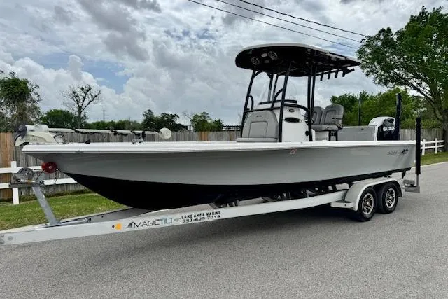 The Image of 2020 Sea Pro 248 Bay boat on a Magic Tilt trailer, parked on a road. - 1