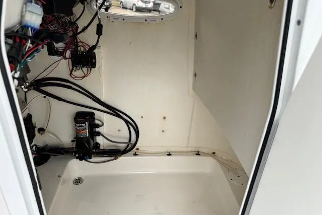 Slide: The Image of Interior view of a 2020 Sea Pro 248 Bay boat's compartment with wiring and pump system. - 15