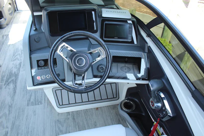 Slide: The Image of 2024 Tahoe Pontoon Cascade Quad Lounge Windshield dashboard with steering wheel and Garmin display. - 14