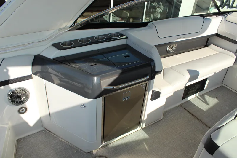 Slide: The Image of 2023 Formula 310 Bowrider I/O interior with seating, cup holders, and a compact fridge. - 12