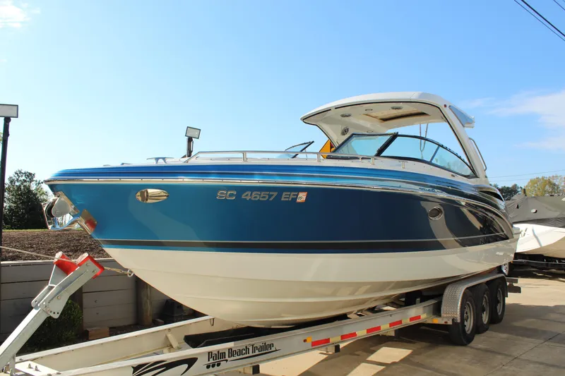 Slide: The Image of 2023 Formula 310 Bowrider I/O boat on trailer, blue and white exterior. - 3