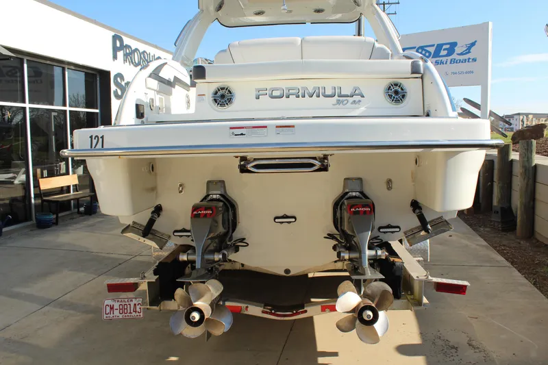 Slide: The Image of 2023 Formula 310 Bowrider I/O boat rear view with dual propellers and sleek design. - 5