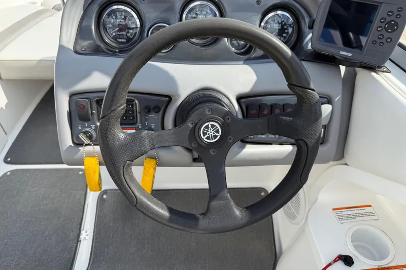 Slide: The Image of 2005 Yamaha Boats SX230 steering wheel and dashboard with gauges and controls. - 14