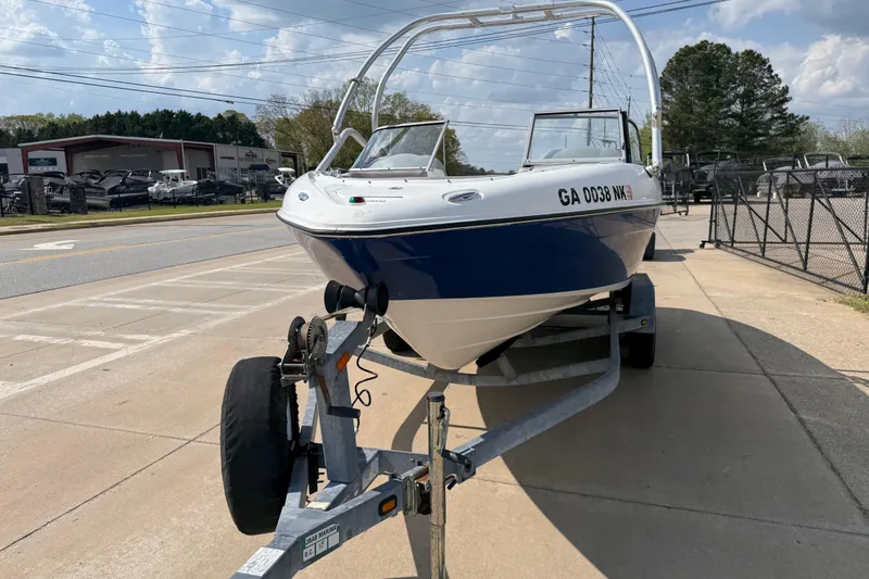Slide: The Image of 2005 Yamaha Boats SX230 on trailer, parked outdoors, blue and white design. - 3