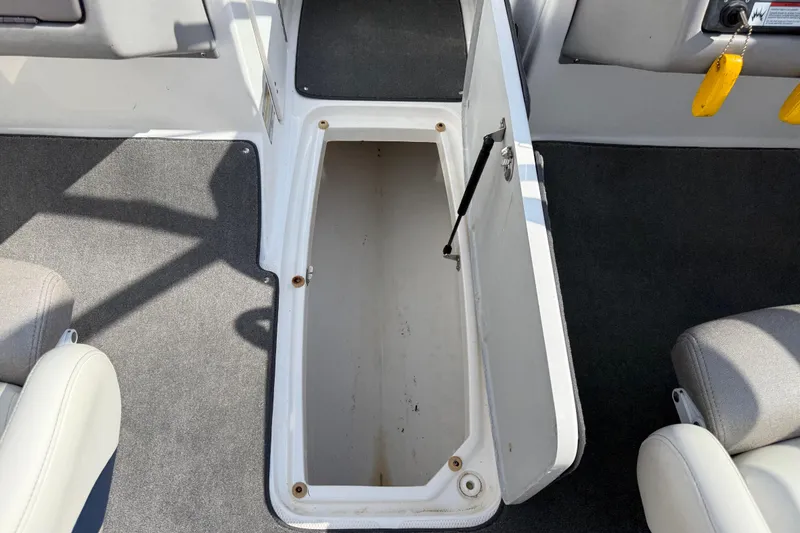 Slide: The Image of Open storage compartment on 2005 Yamaha Boats SX230 with gray carpet interior. - 36