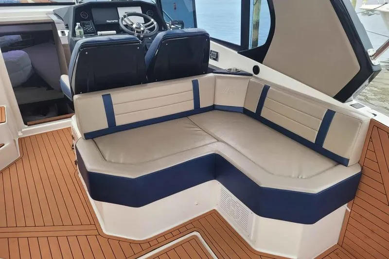 Slide: The Image of 2024 Hanover 387 boat interior with cushioned seating and modern helm. - 7