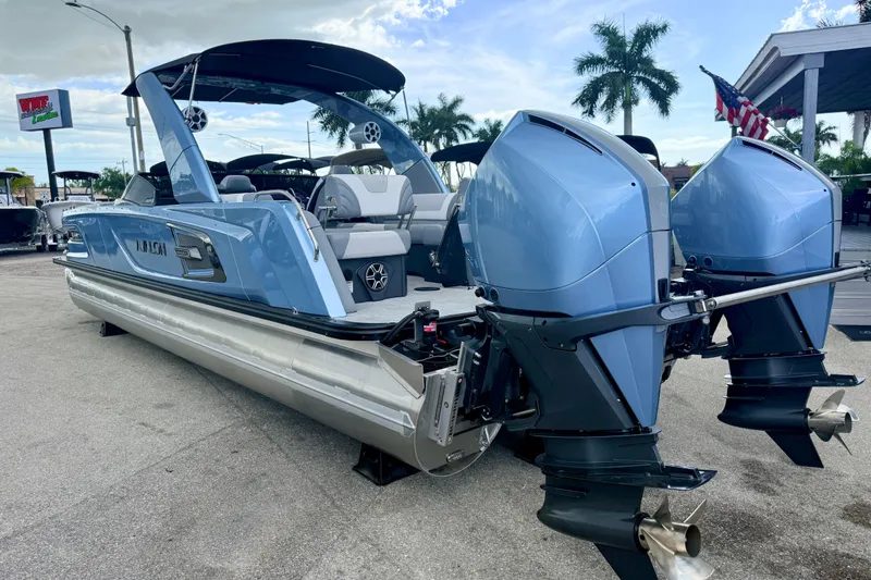 Slide: The Image of 2026 Avalon 2 pontoon boat with dual outboard motors, parked outdoors. - 13