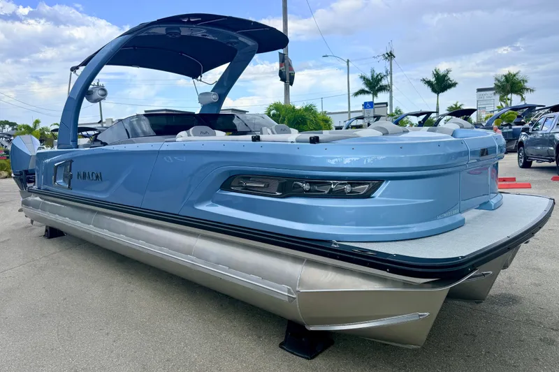Slide: The Image of 2026 Avalon 2 pontoon boat in light blue, parked outdoors under a cloudy sky. - 6