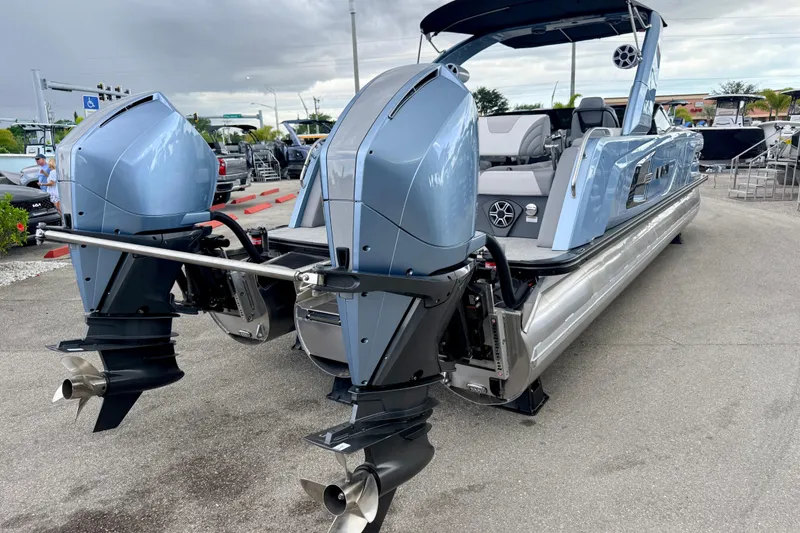 Slide: The Image of 2026 Avalon 2 pontoon boat with dual outboard motors, showcased on a paved lot. - 9
