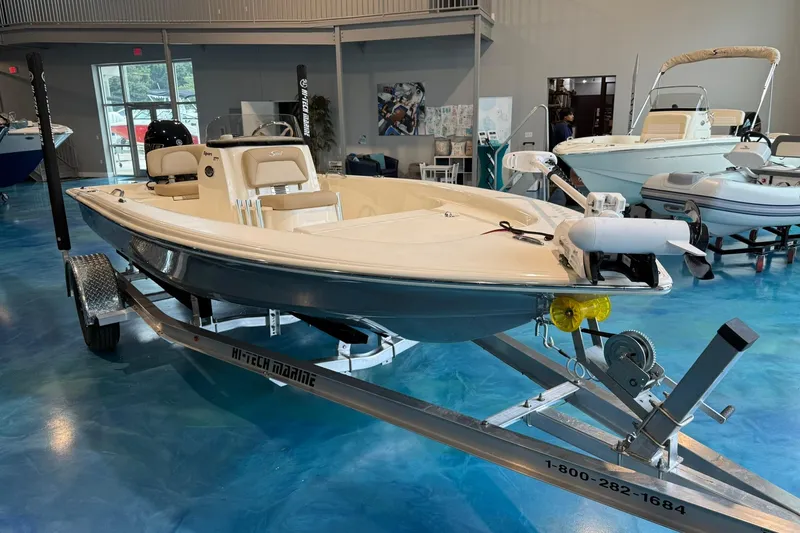 Slide: The Image of 2026 Scout 177 XSS boat on trailer in showroom, featuring sleek design and modern amenities. - 1