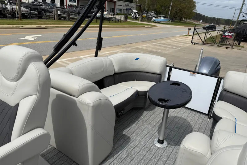 Slide: The Image of 2022 Starcraft SLS 3 boat interior with plush seating and table, parked near a road. - 25