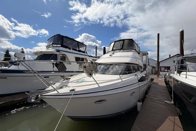 The Image of 2005 Carver 41 Cockpit Motor Yacht docked under a partly cloudy sky. - 0